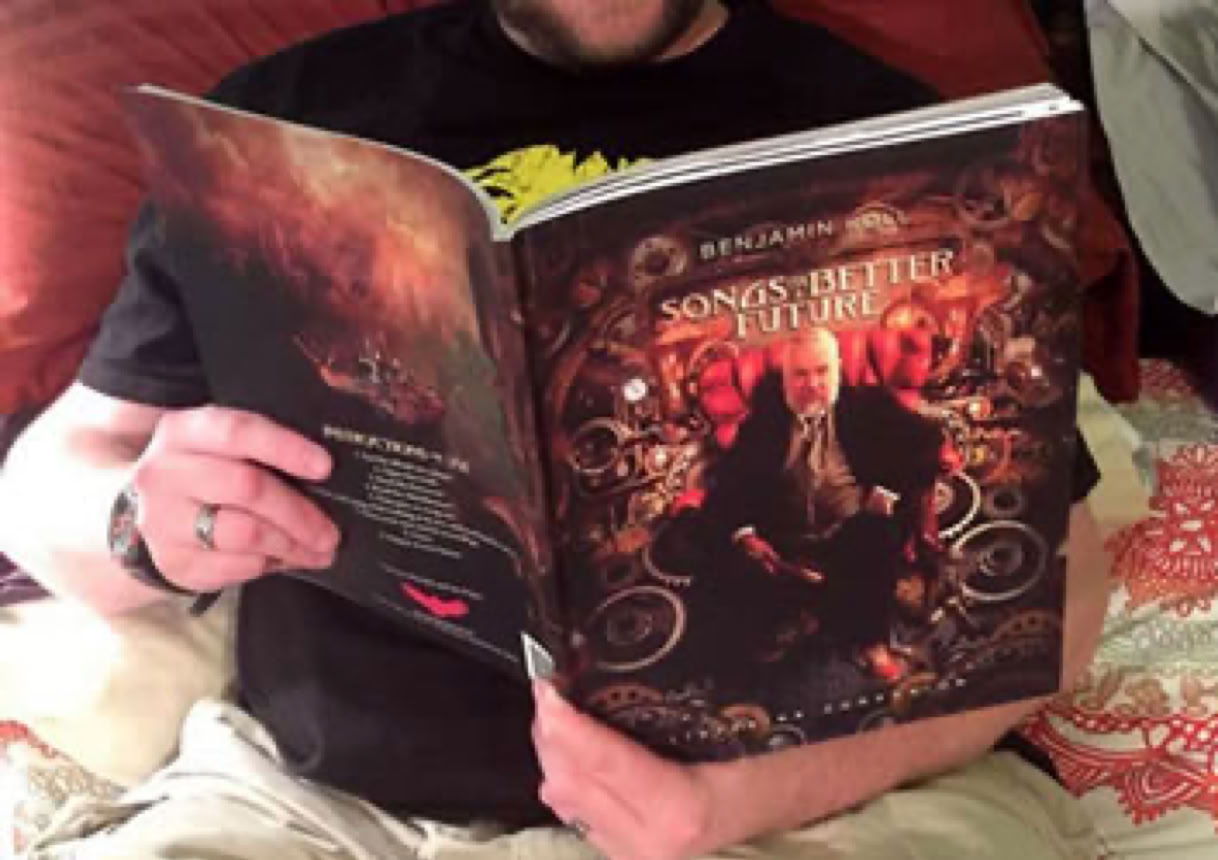 Fan reading the Songs For A Better Future Listening Companion book